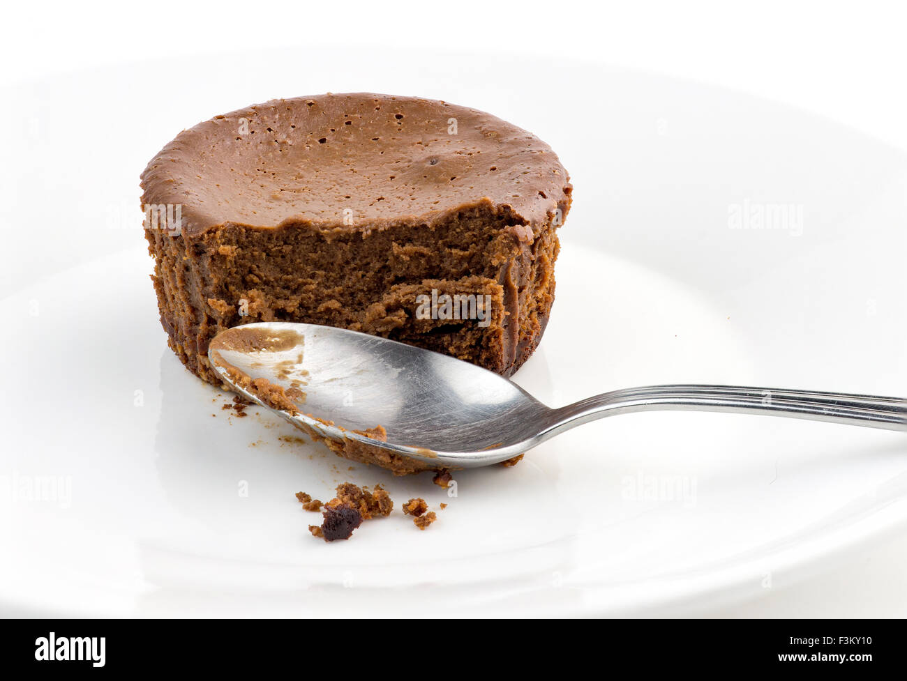 Macro closeup di mezzo mangiato torta al cioccolato muffin con cucchiaio sporco Foto Stock