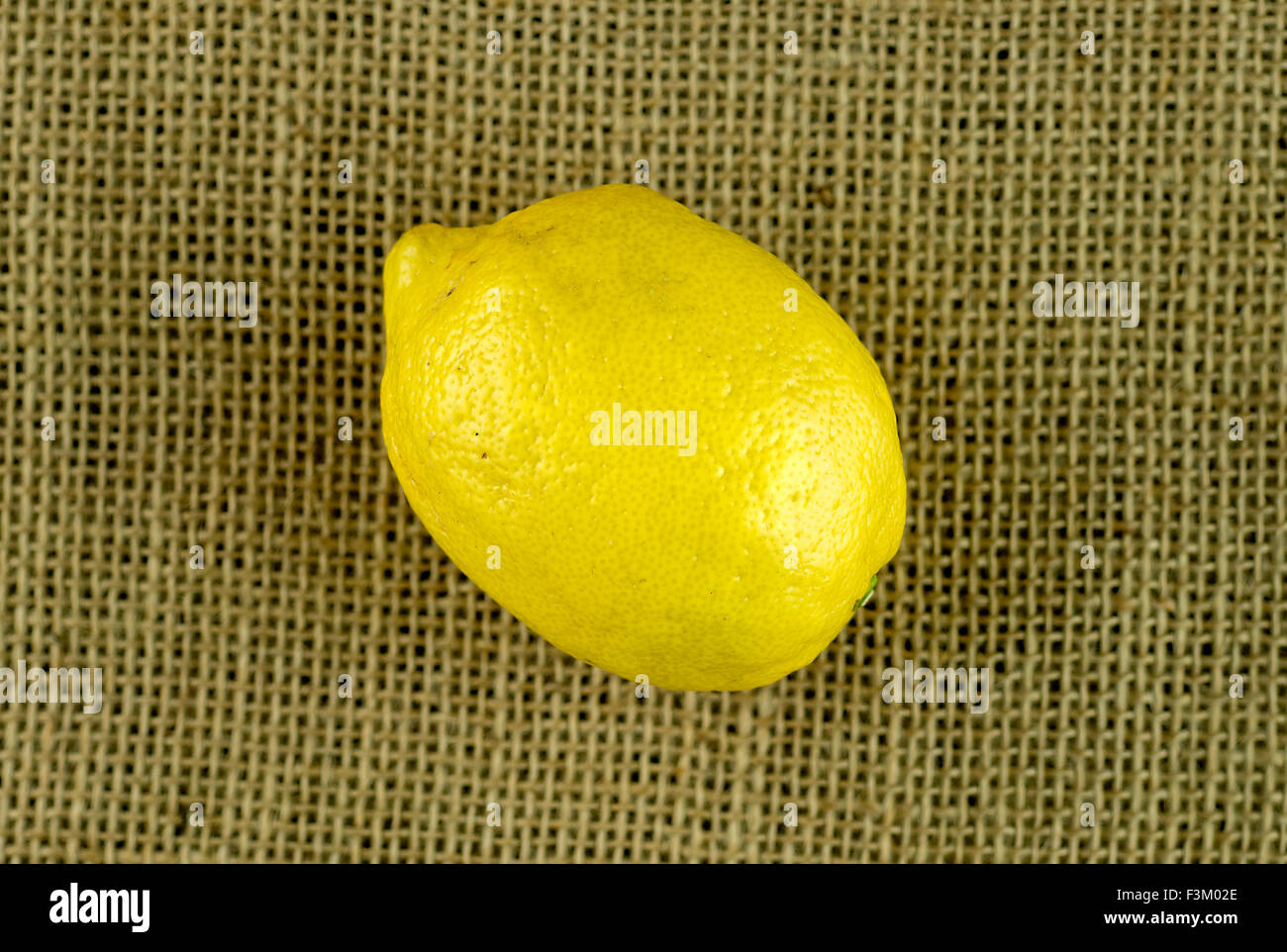 Un limone sul rustico sfondo di tela Foto Stock