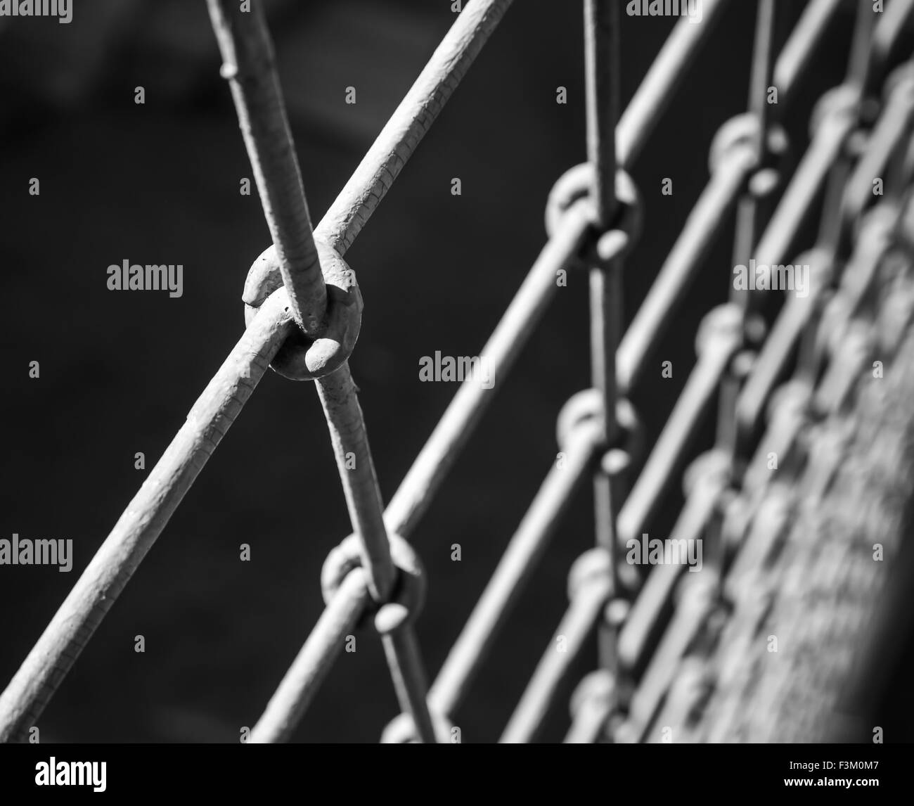 Acciaio ruvido recinzione frammento macro nero su sfondo sfocato Foto Stock