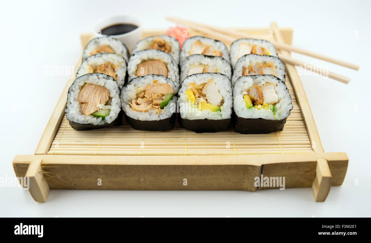 Tradizionale vassoio di bambù con un assortimento di teriyaki e pollo fritto sushi con bacchette, la salsa di soia e zenzero sott'aceto Foto Stock