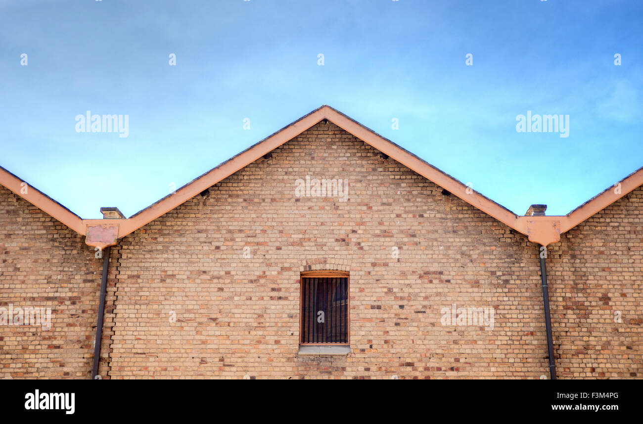 Il vecchio edificio di mattoni con barre di acciaio nella finestra Foto Stock