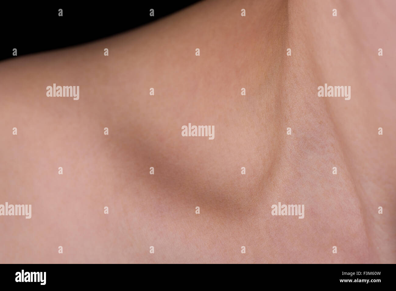 Un abstract colpo di una donna di collo, la clavicola e la spalla con una piccola quantità di sfondo nero che mostra. Foto Stock