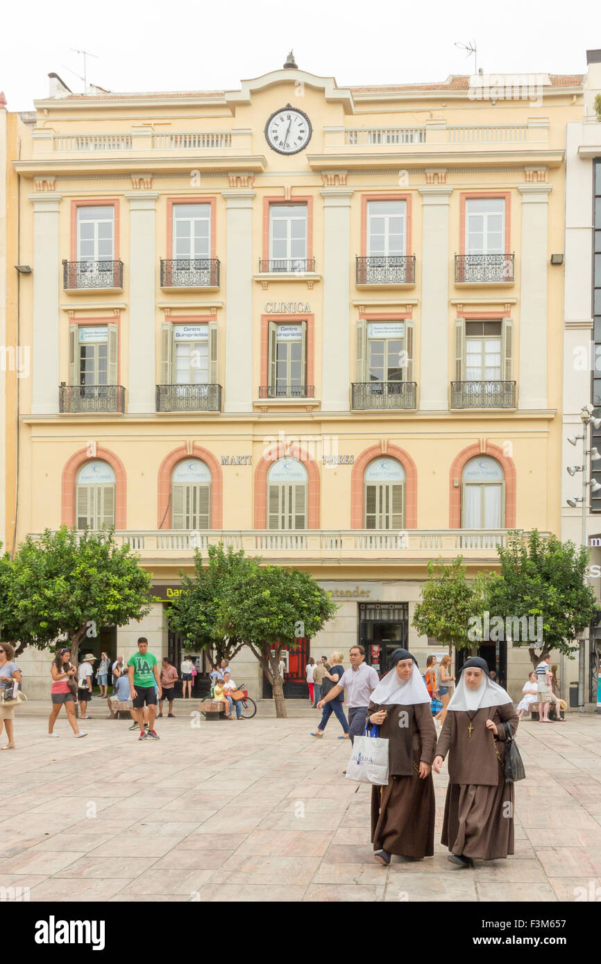 Due monache a piedi attraverso la Plaza de la Constitucion, Malaga, Andalusia, Spagna Foto Stock