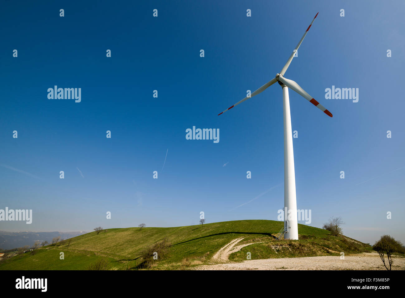 Un impianto eolico è in uso in un paesaggio collinare Foto Stock