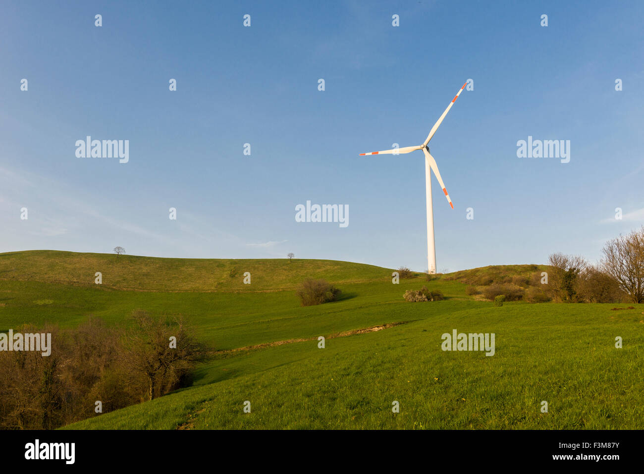 Un impianto eolico è in uso in un paesaggio collinare Foto Stock
