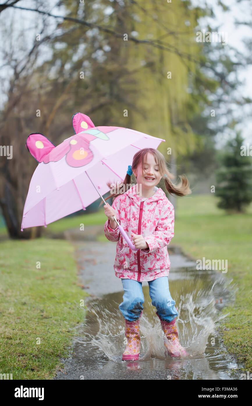 Ragazza,Rosa,Jumping,Ombrello,Pozza Foto Stock