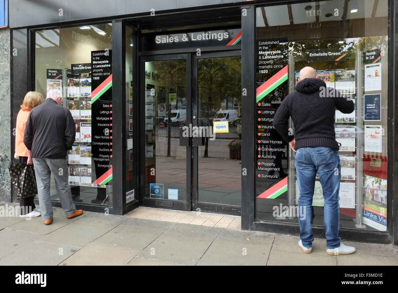Un uomo che guarda nel agenti immobiliari vetrina per visualizzare le proprietà per la vendita, Liverpool, Merseyside, Regno Unito Foto Stock