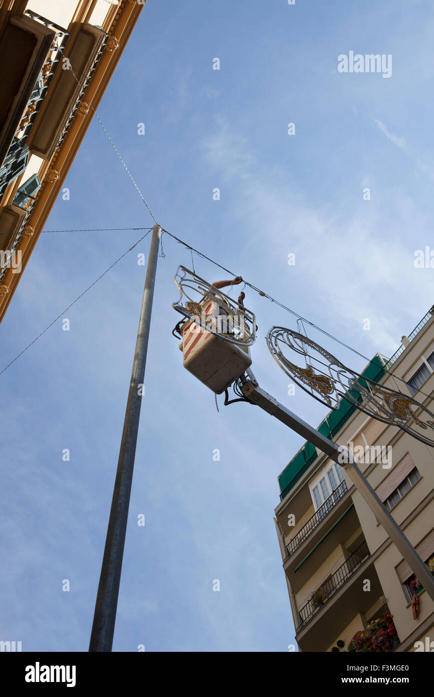Elettricista rimane su cherry picker e riparazioni elettriche decorazione della città Foto Stock