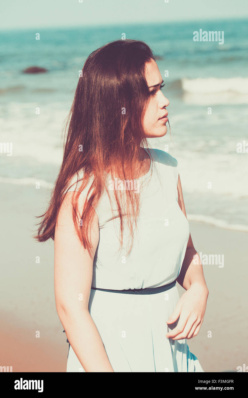 Storico giovane donna sulla spiaggia che indossa un vestito blu Foto Stock