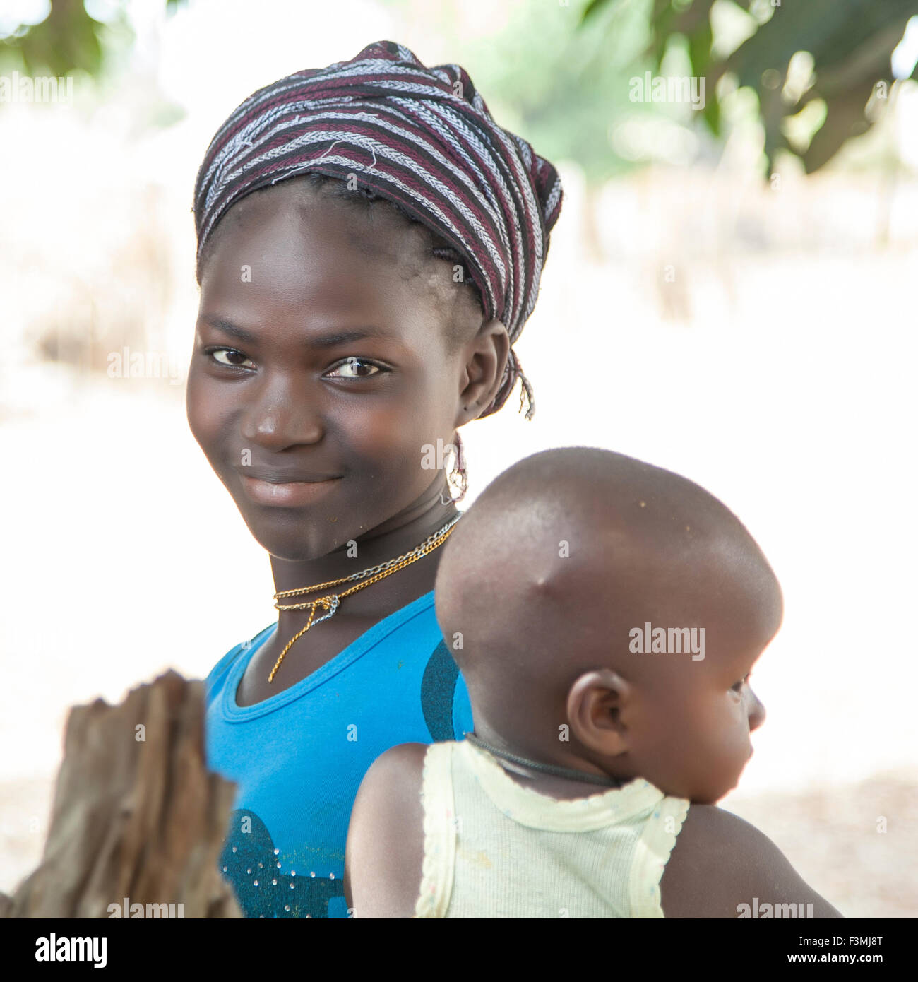 Ritratto di un non ben identificato bella ragazza africana con il suo bambino bambino mentre partecipavo a una riunione di villaggio Foto Stock