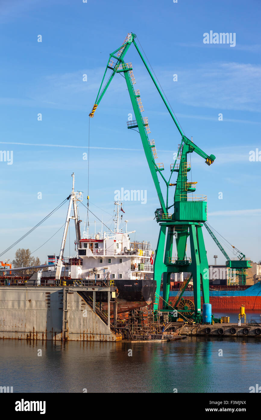 Una vista di una grande nave in riparazione in bacino di carenaggio di un cantiere navale. Foto Stock