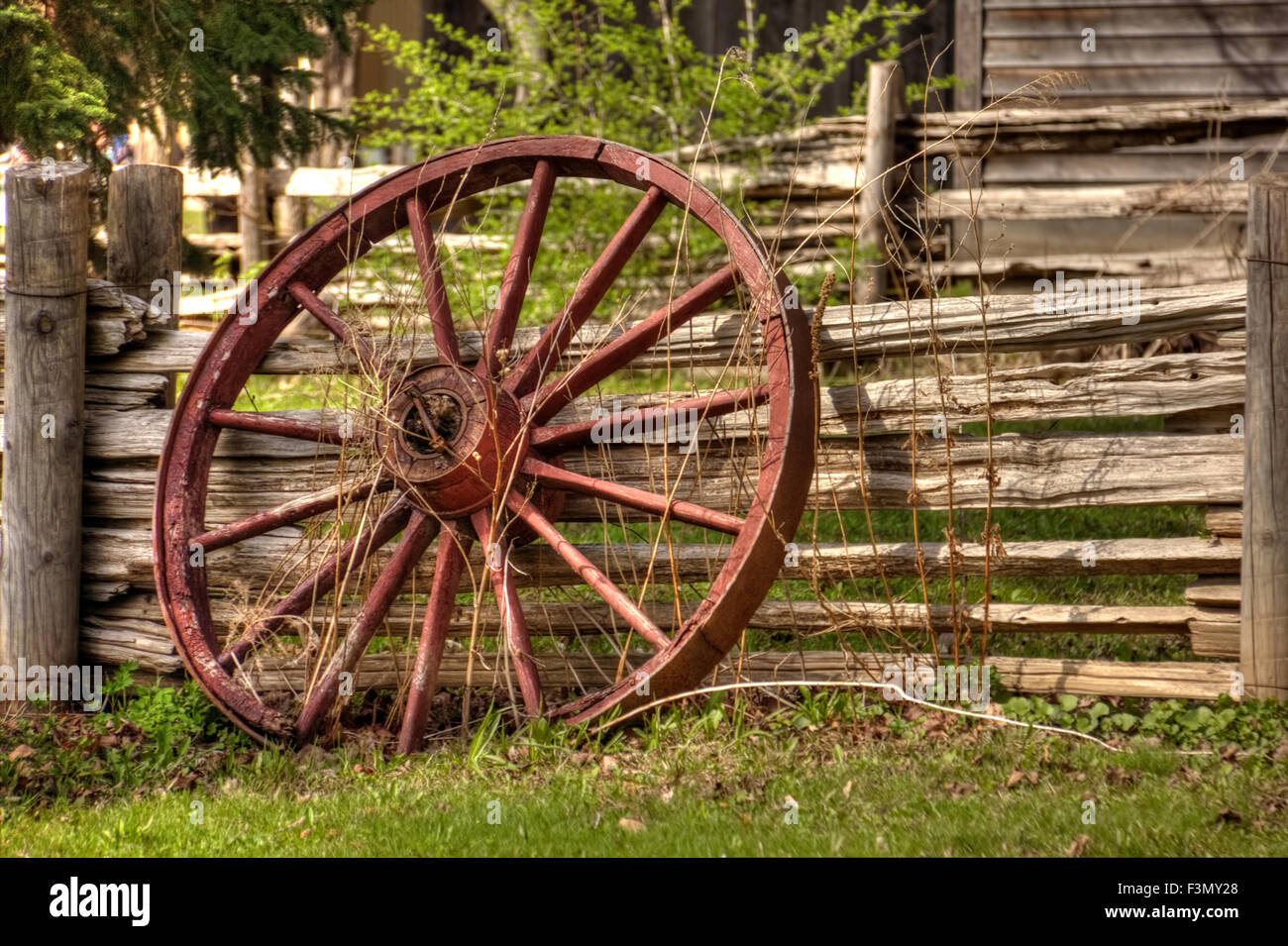 Un unico carro rustico di inclinazione della ruota contro la recinzione di legno. Foto Stock