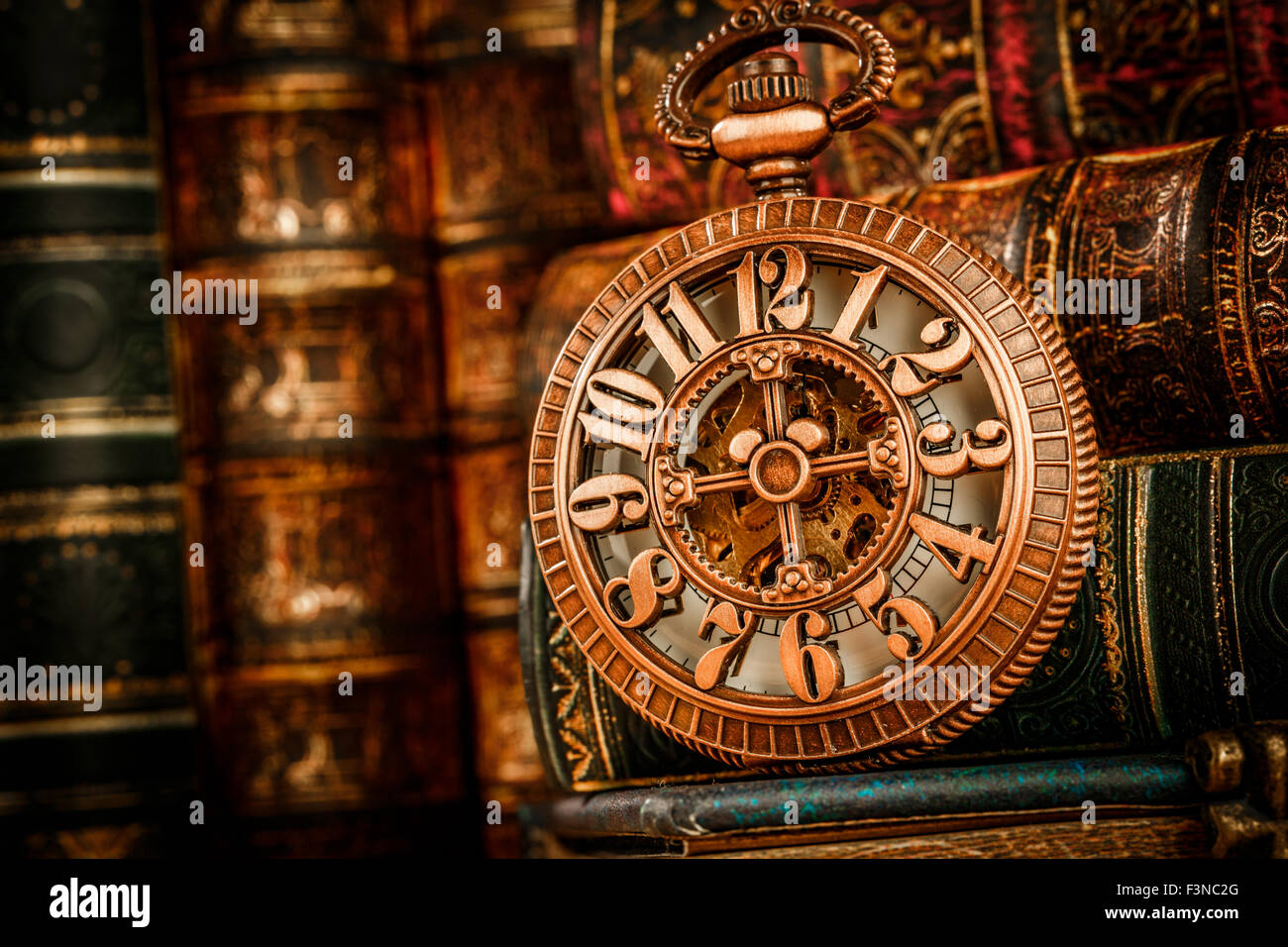 Vintage antico orologio da tasca sullo sfondo di libri antichi Foto Stock