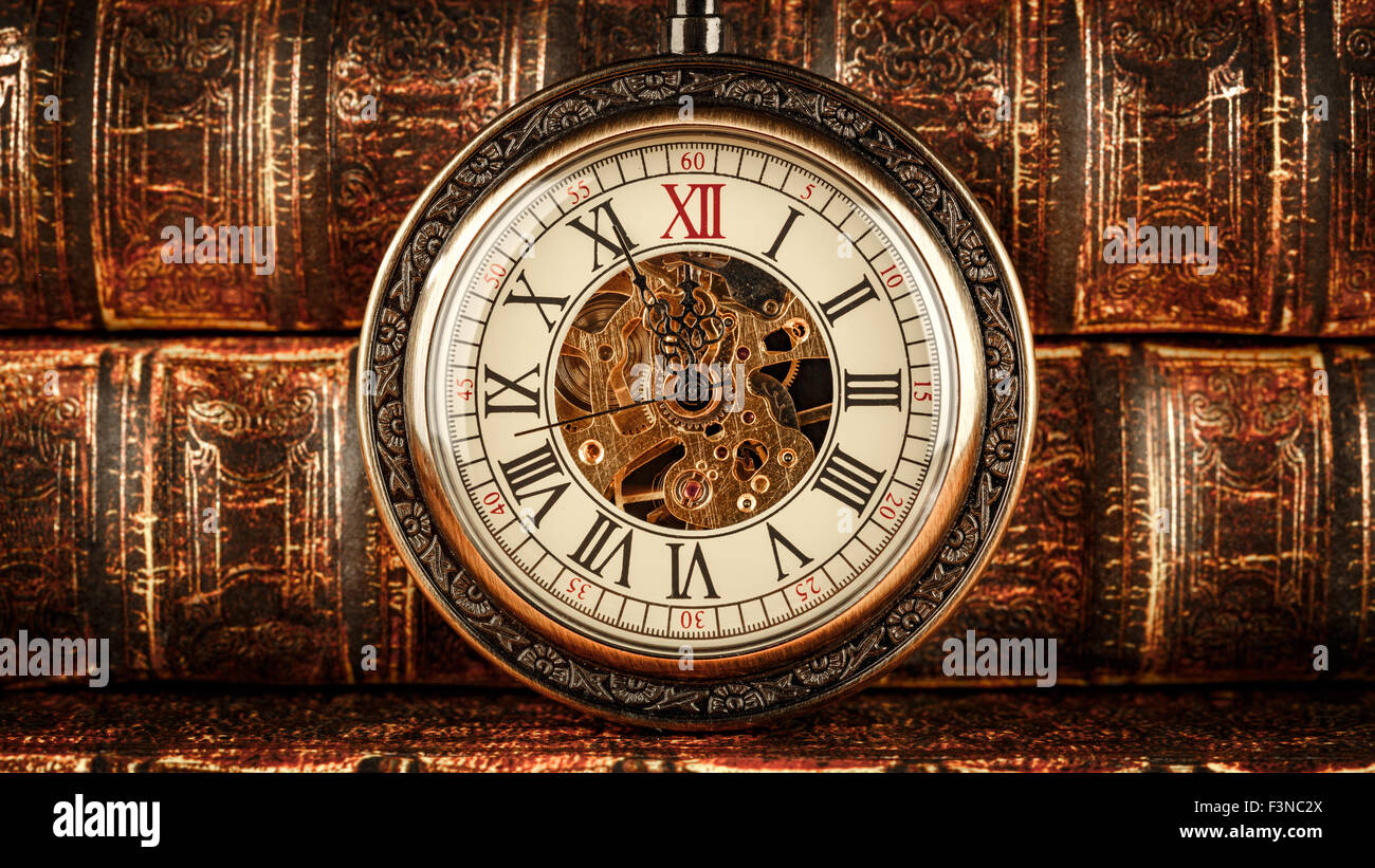 Vintage antico orologio da tasca sullo sfondo di libri antichi Foto Stock