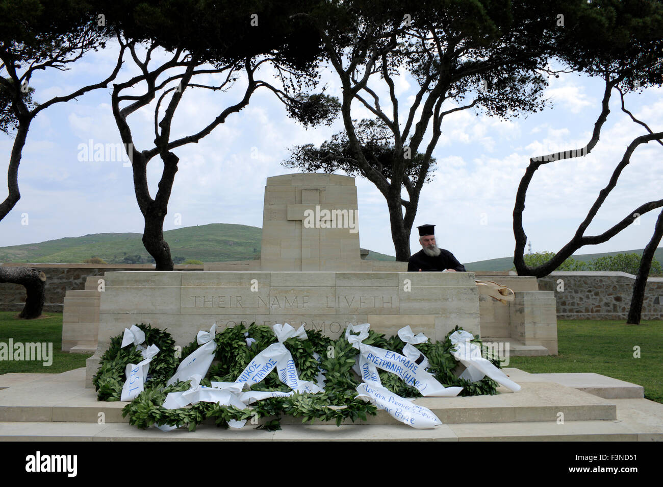 La croce di pietra includono lastra, di cui ghirlande e un sacerdote dopo la fine della cerimonia tenutasi nel cimitero CWGC, est. Moudros, GR Foto Stock