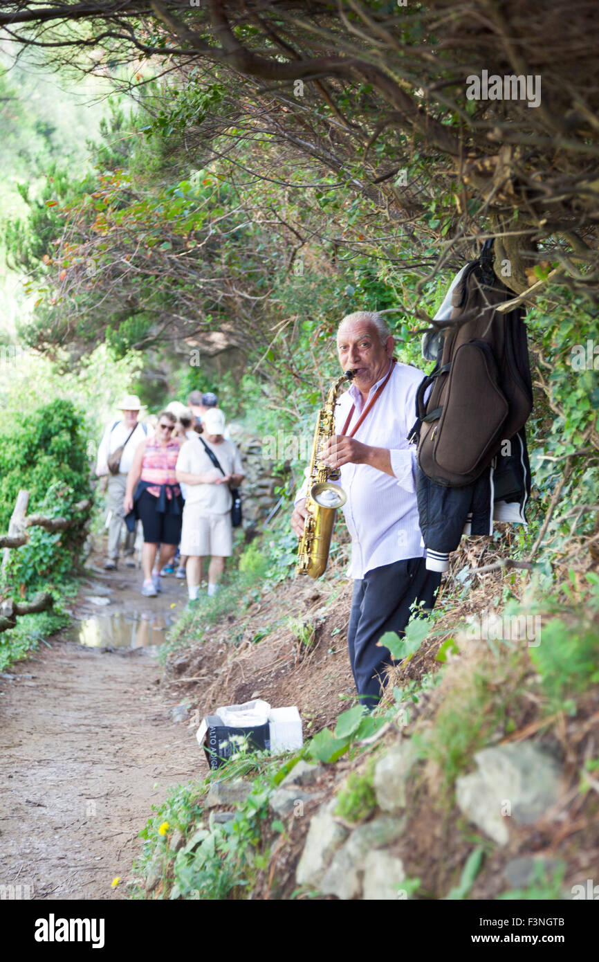 Musicista suonare il sassofono sul sentiero da Monterosso al Mare a Vernazza, Cinque Terre, Italia Foto Stock