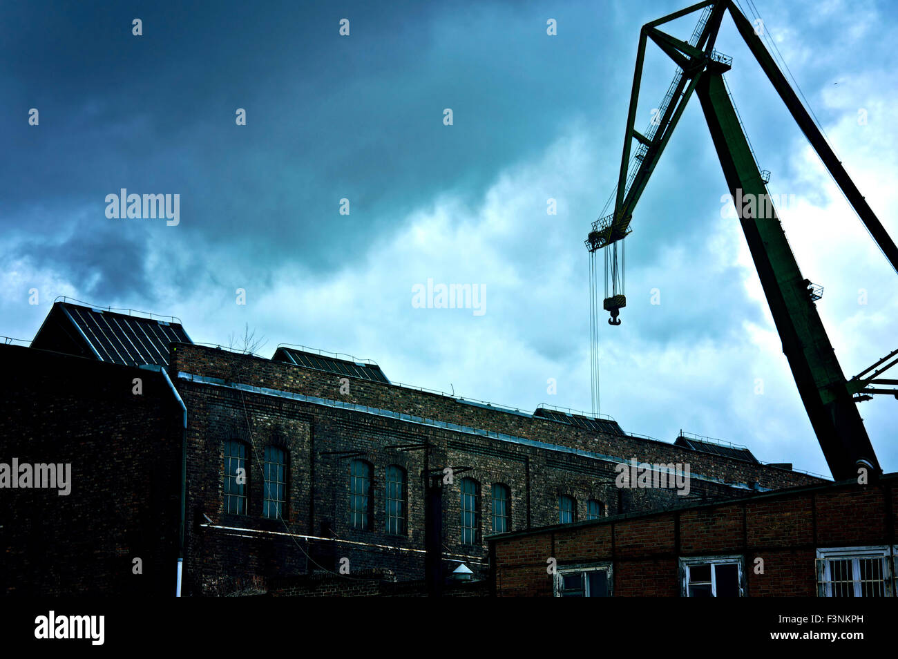 Buio e cupo nuvole sulla vecchia area industriale abbandonata con la gru. Foto Stock