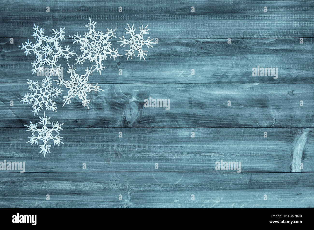Fiocchi di neve bianco su blu sullo sfondo di legno. Vacanze invernali decorazione Foto Stock