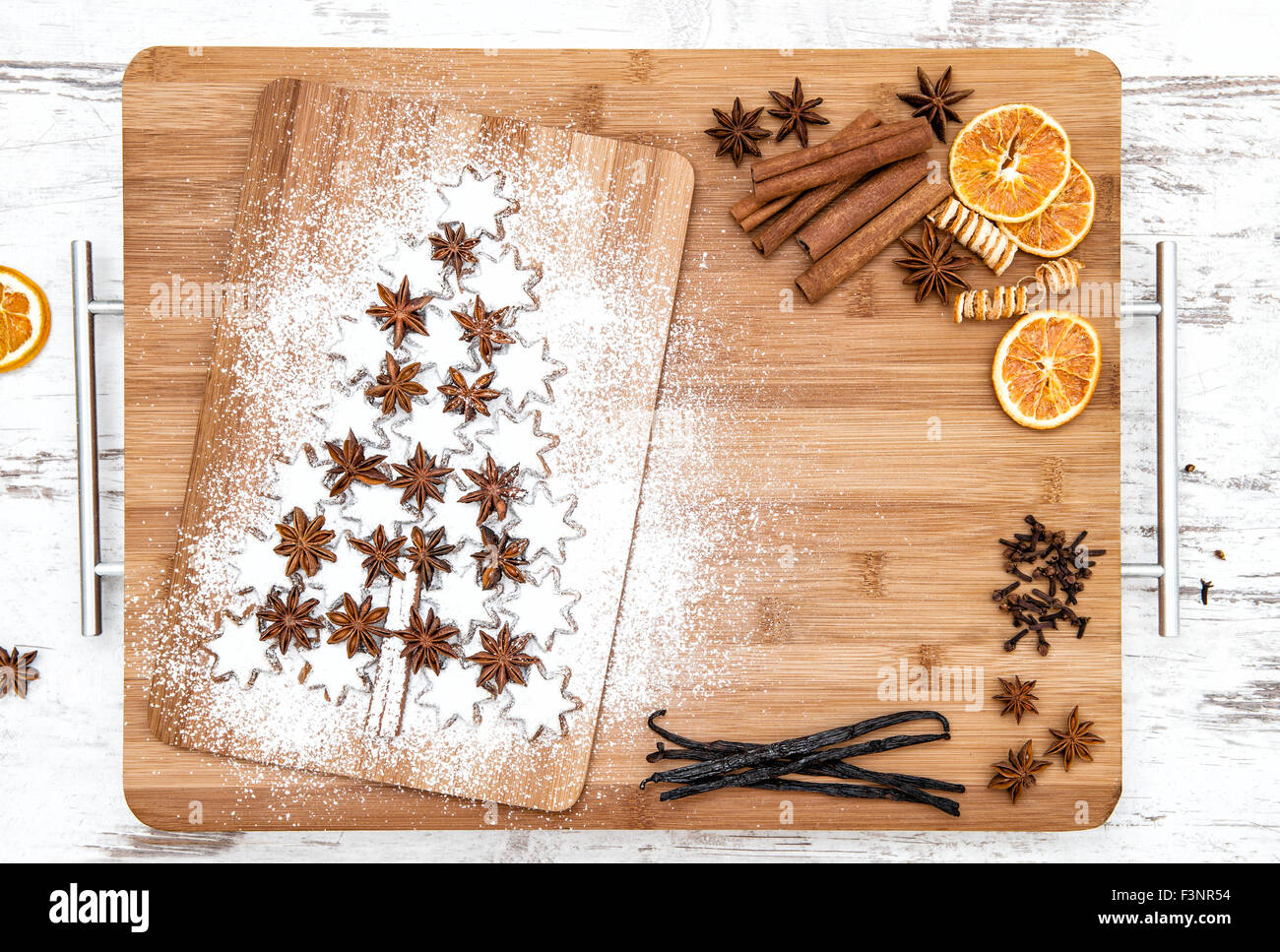 Biscotti di Natale stelle di cannella e spezie su sfondo di legno. Baccelli di vaniglia, chiodi di garofano, anice stellato e cannella. Cibo di festa Foto Stock