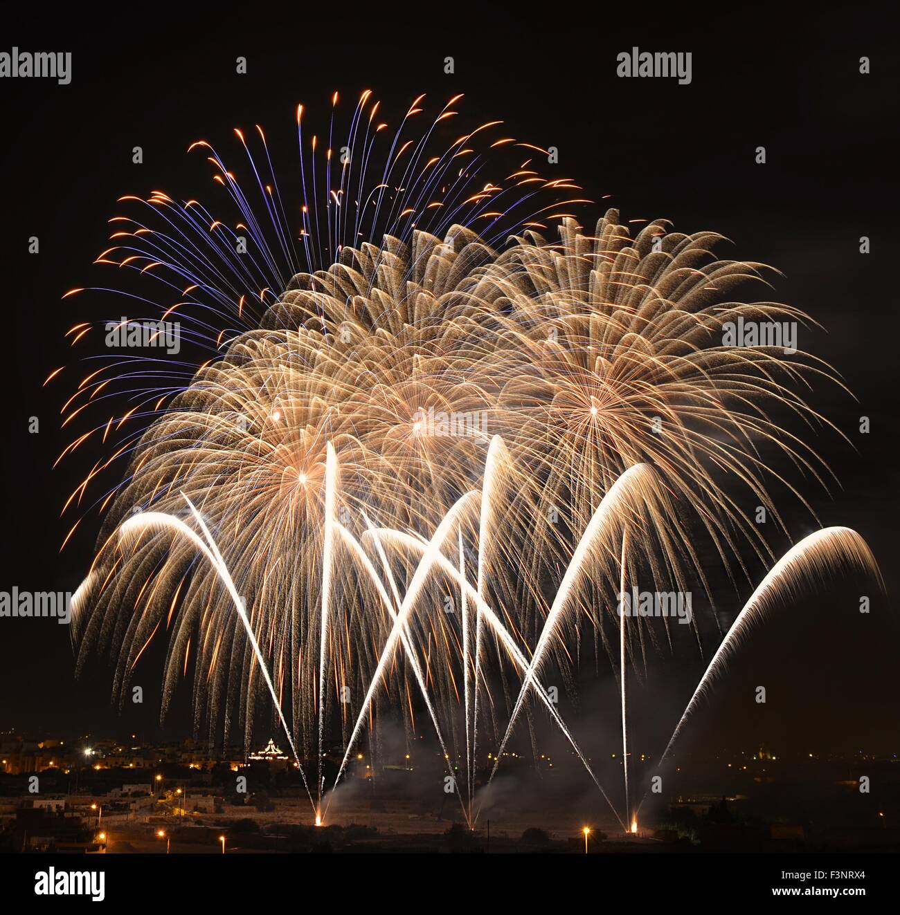 Fuochi d'artificio,colorato sfondo di fuochi d'artificio,fuochi d'artificio esplosione nel cielo scuro con silhoutte di villaggio in Qrendi,Malta, fuochi d'artificio Foto Stock