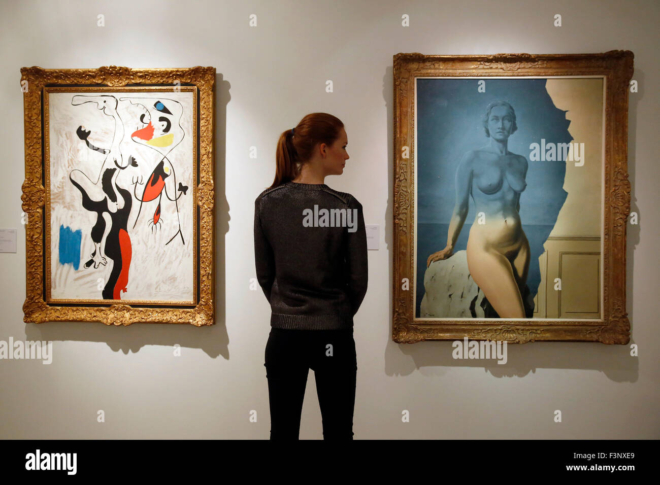 Un Christie's dipendente pone con artista Joan Miro 'Homme et Femme' (L) e René Magritte 'Le Mirroir Universo!' alla casa d'aste Christie's di Londra, Regno Unito, Firday Ottobre 9, 2013. Essi sono tenuti a raggiungere US $ 3 milioni di dollari e a 5 milioni di dollari rispettivamente quando arrivano all asta a New York nel mese di novembre. . Esse saranno sul dispay nel Regno Unito durante il fregio decorato con Arte Fiera settimana fino al mese di ottobre 17. Foto Stock