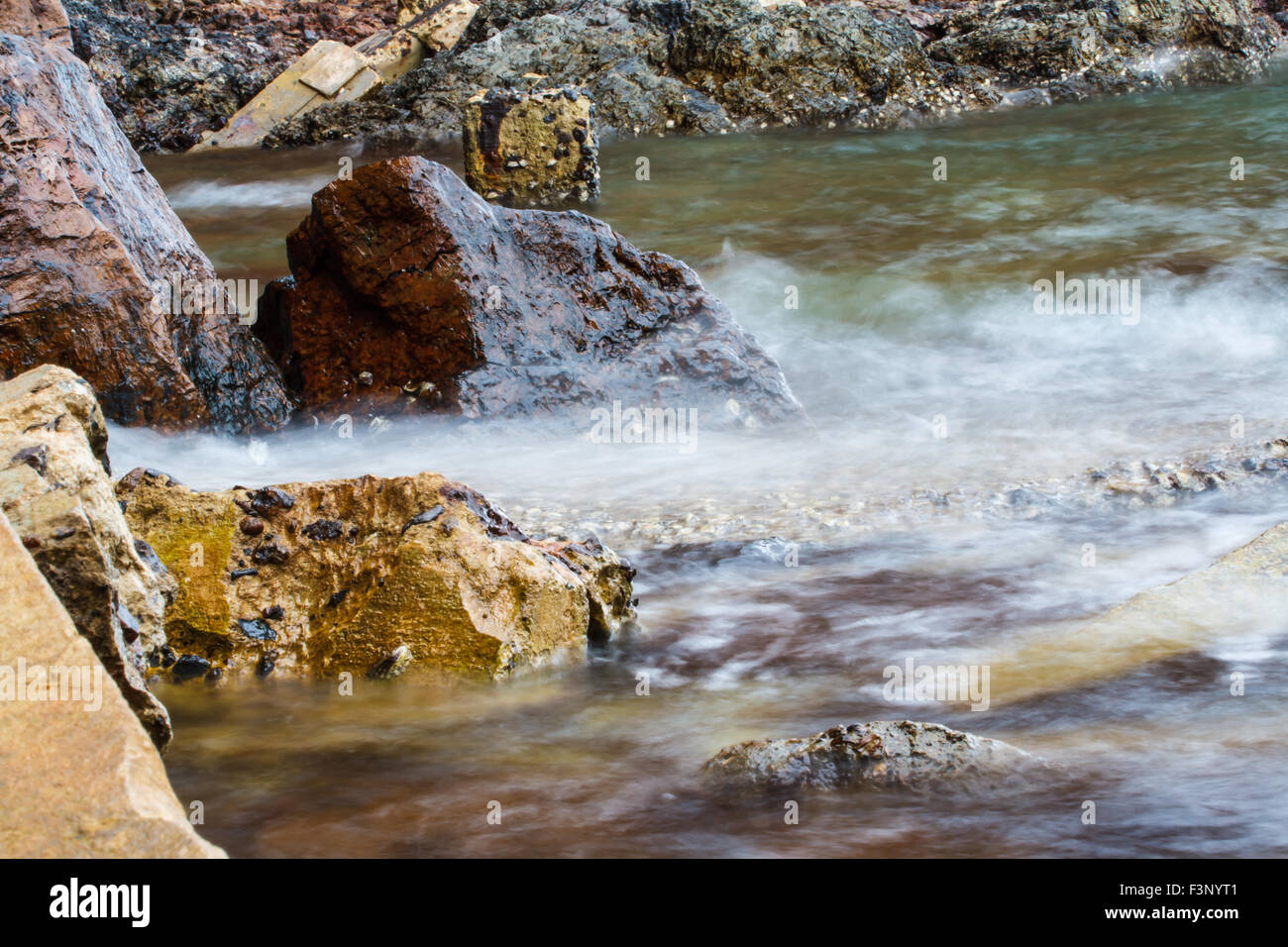 Le onde battono le rocce Foto Stock