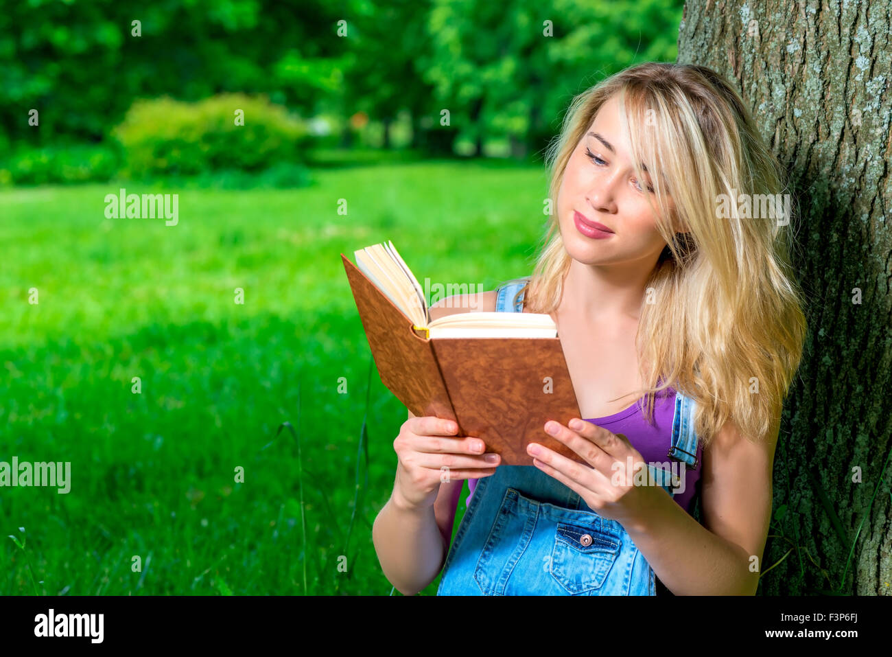 Ritratto di uno studente con un libro nel parco Foto Stock