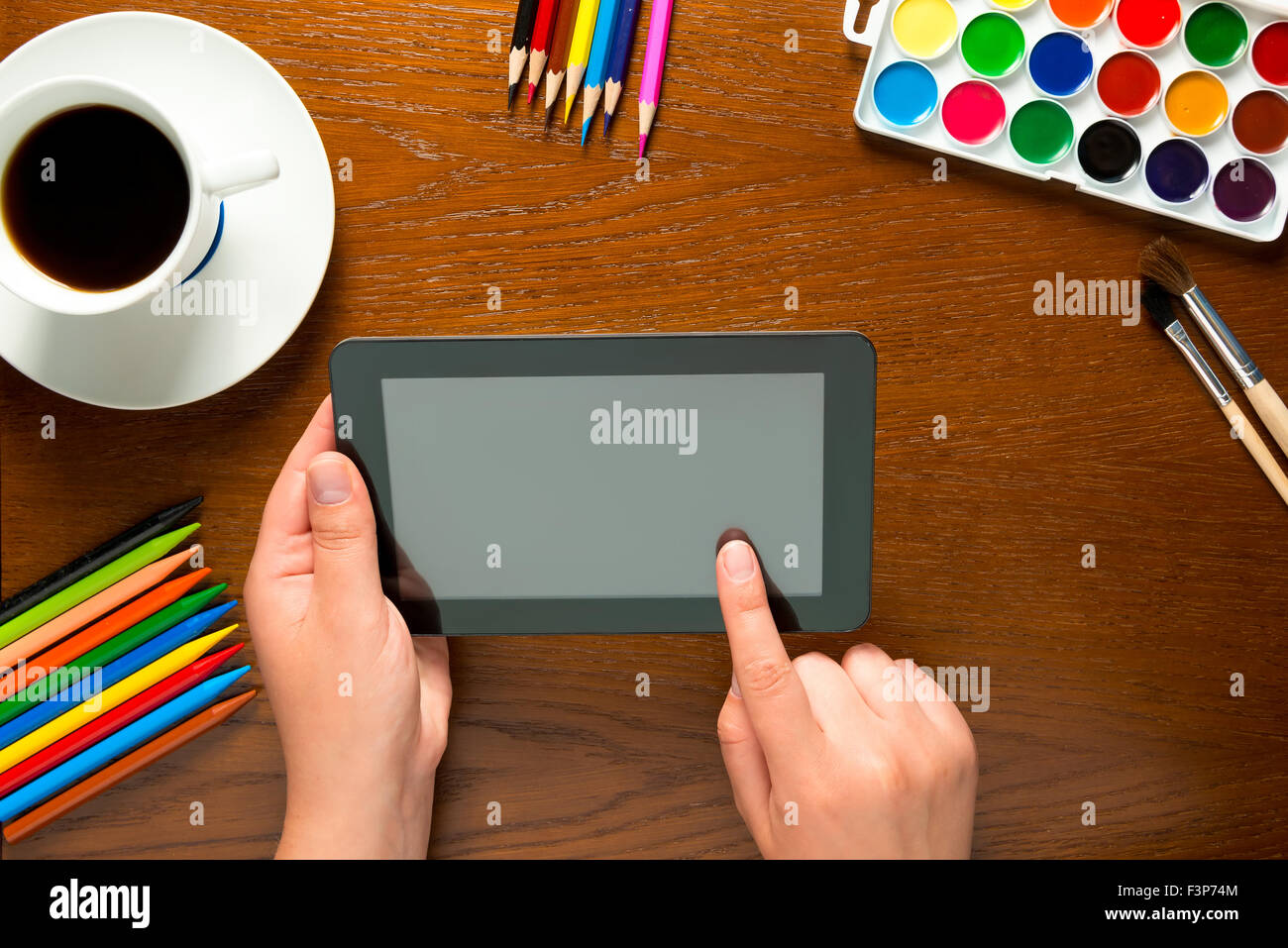 Tablet e gli strumenti di disegno sul tavolo e le mani Foto Stock