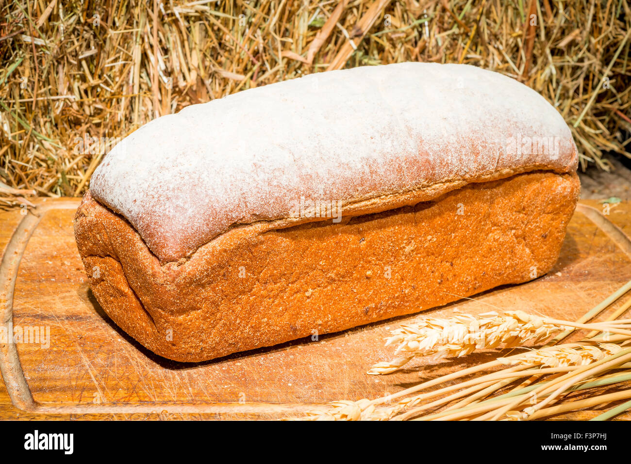 Una pagnotta di pane di grano su un tagliere Foto Stock