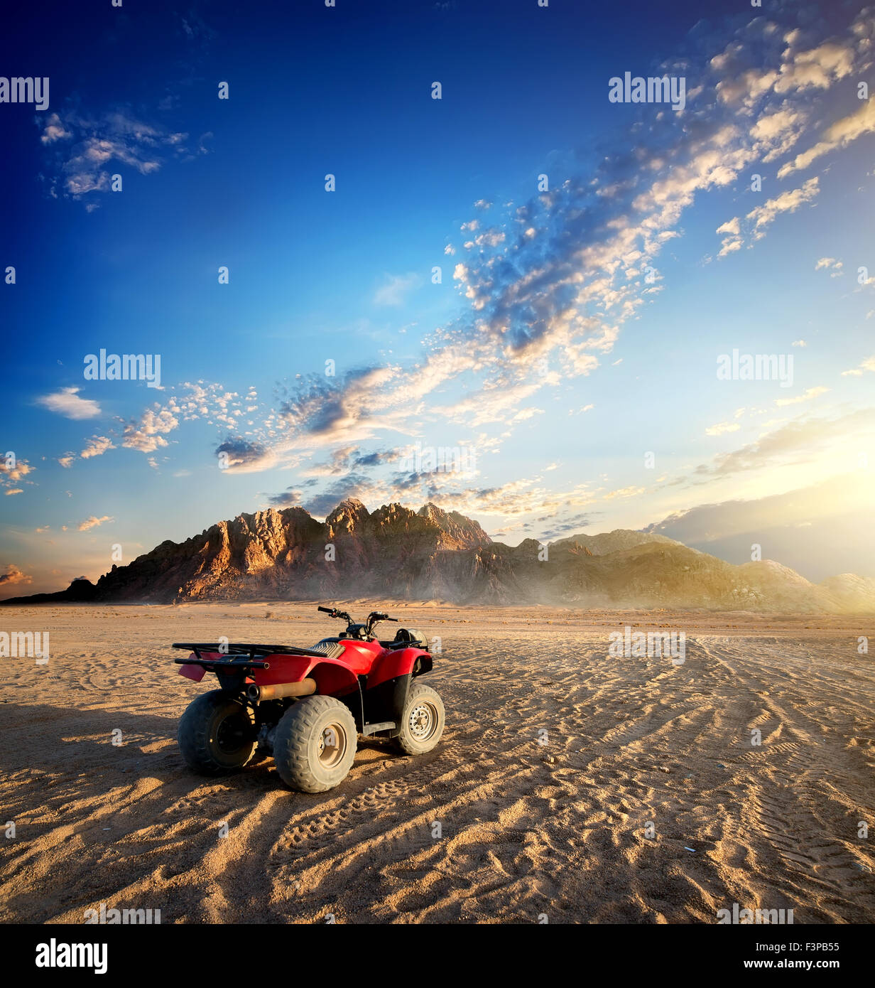 Moto Quad nel deserto di sabbia vicino mountain Foto Stock