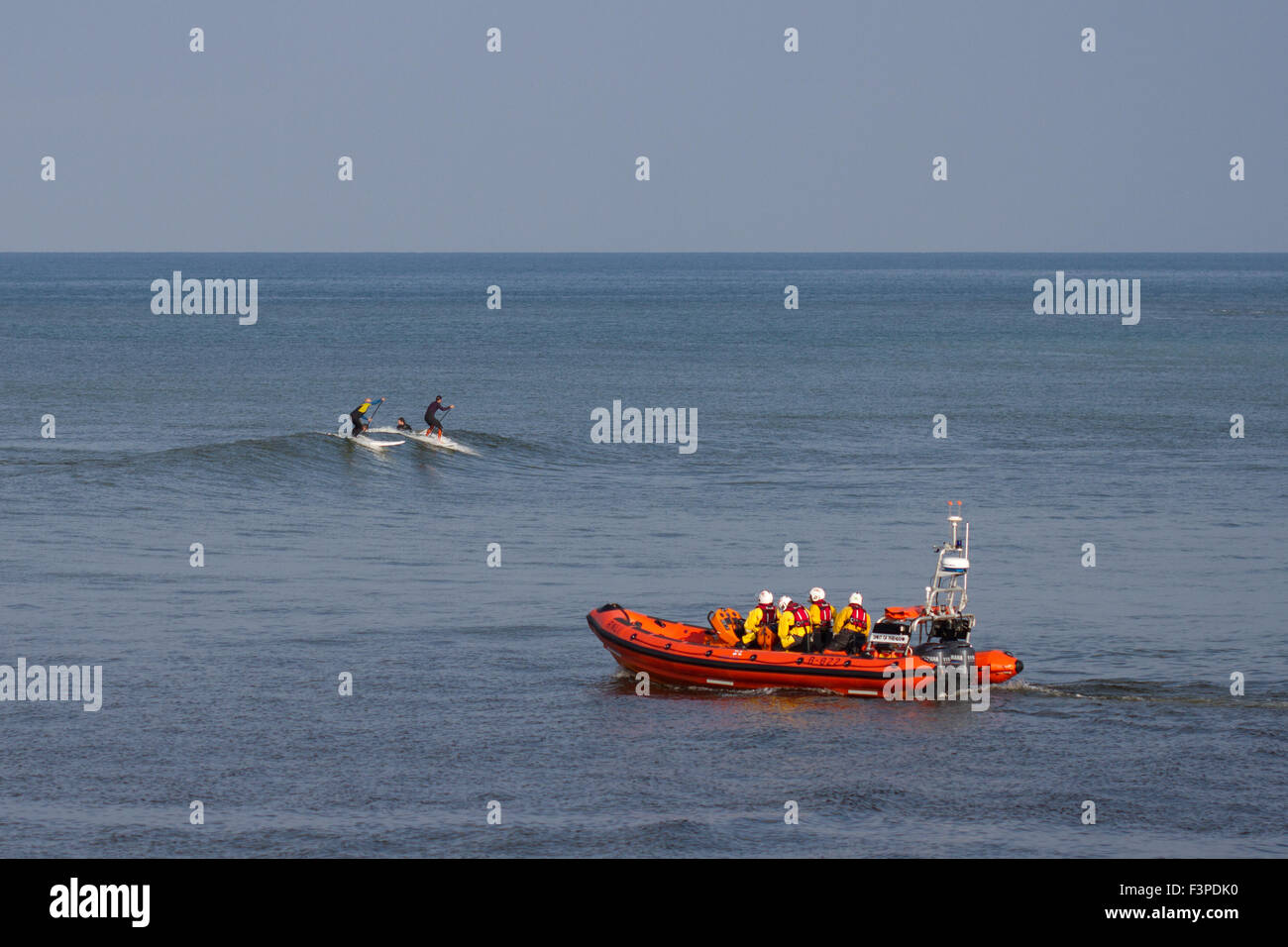 Surfisti cavalcare le onde sulla costa di Aberystwyth Foto Stock