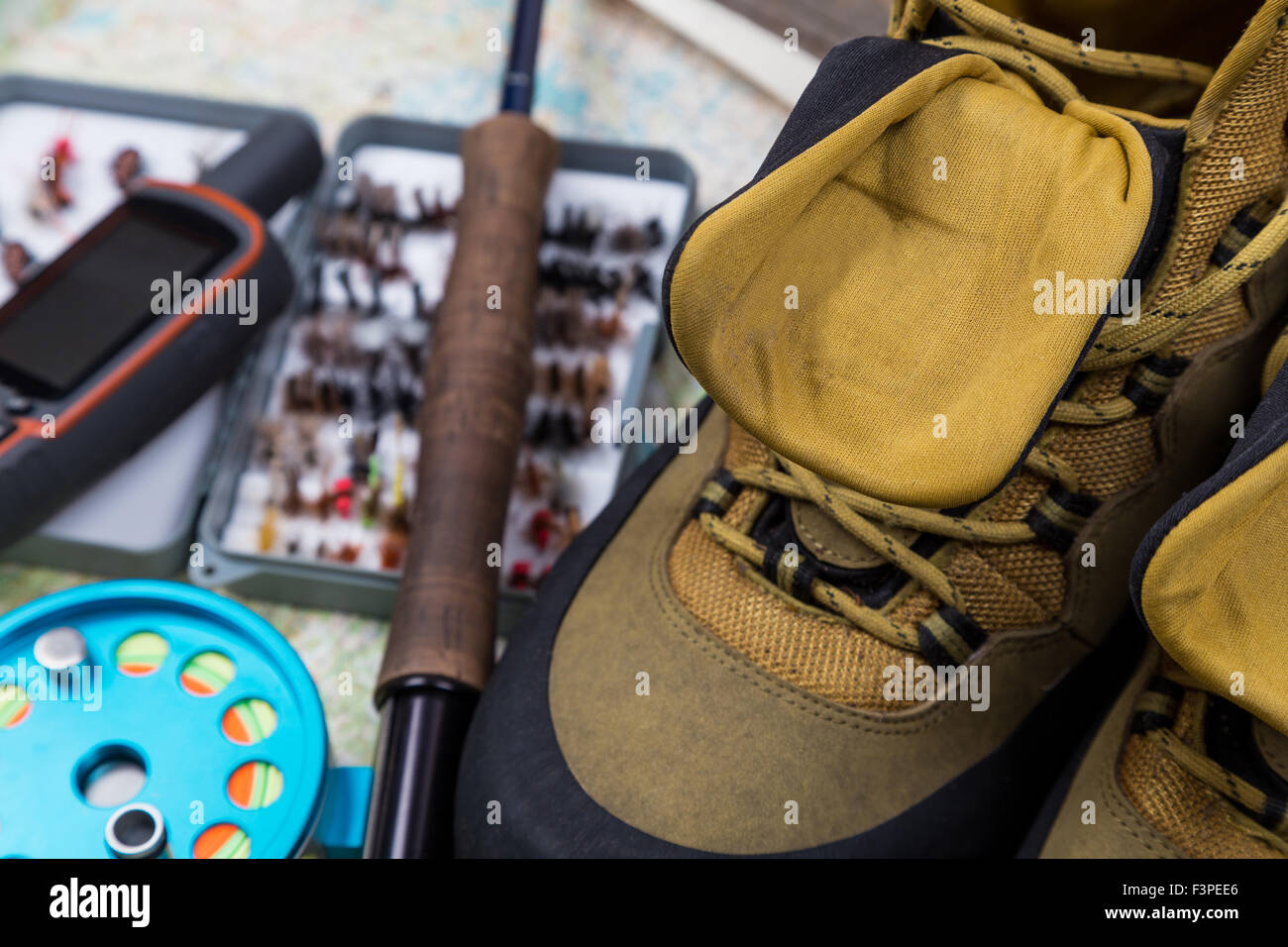 Calzature impermeabili con la pesca affronta e su carta di sfondo della mappa Foto Stock