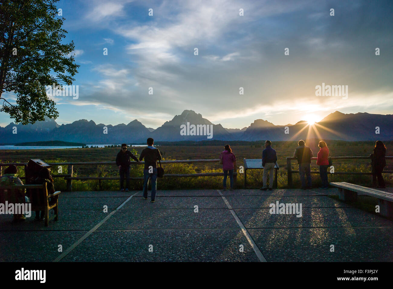 Il turista a godere il tramonto vista dal cortile del famoso & storica Jackson Lake Lodge; il Parco Nazionale del Grand Teton; Teton gamma Foto Stock