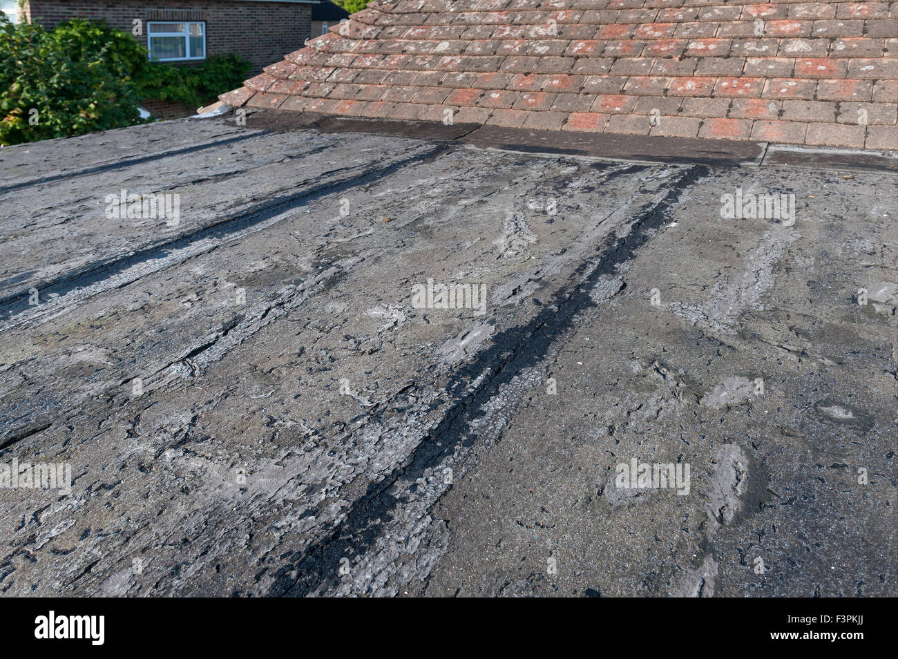 In mancanza e deteriorando tetto piatto fessurato fino apertura comune di crepe del tetto perì vecchio e perde perirono superficie feltro di bitume Foto Stock