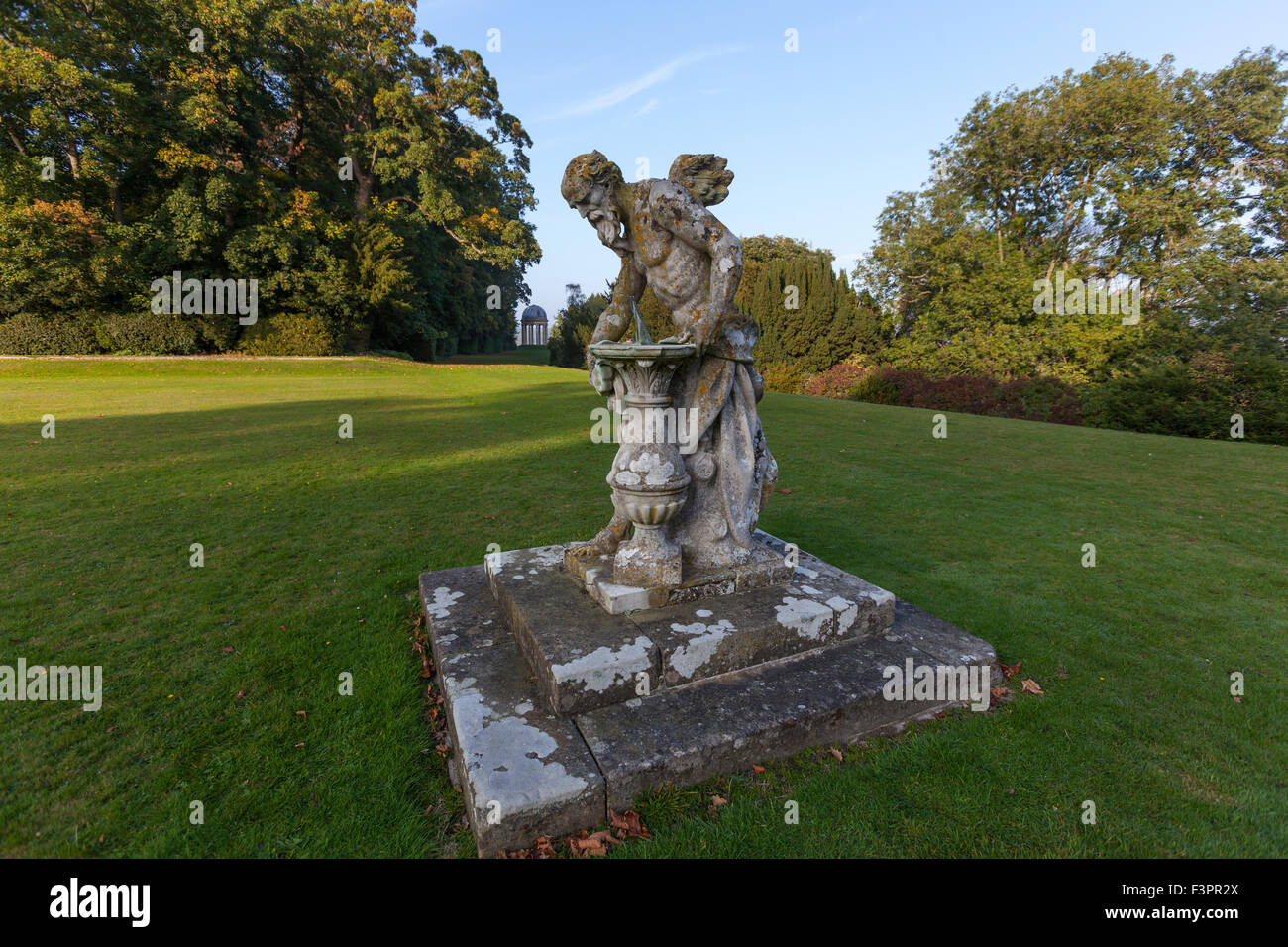 Padre Tempo scultura in pietra e il tempio ionico in Duncombe Park, Helmsley, North Yorkshire, Inghilterra, Regno Unito Foto Stock