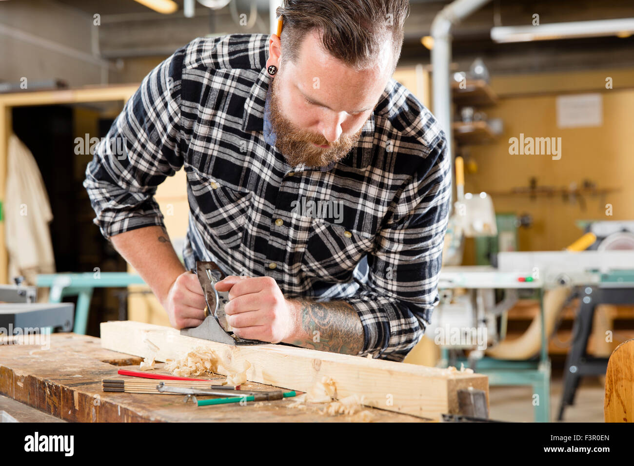 Carpenter lavora con piano su asse di legno in officina Foto Stock