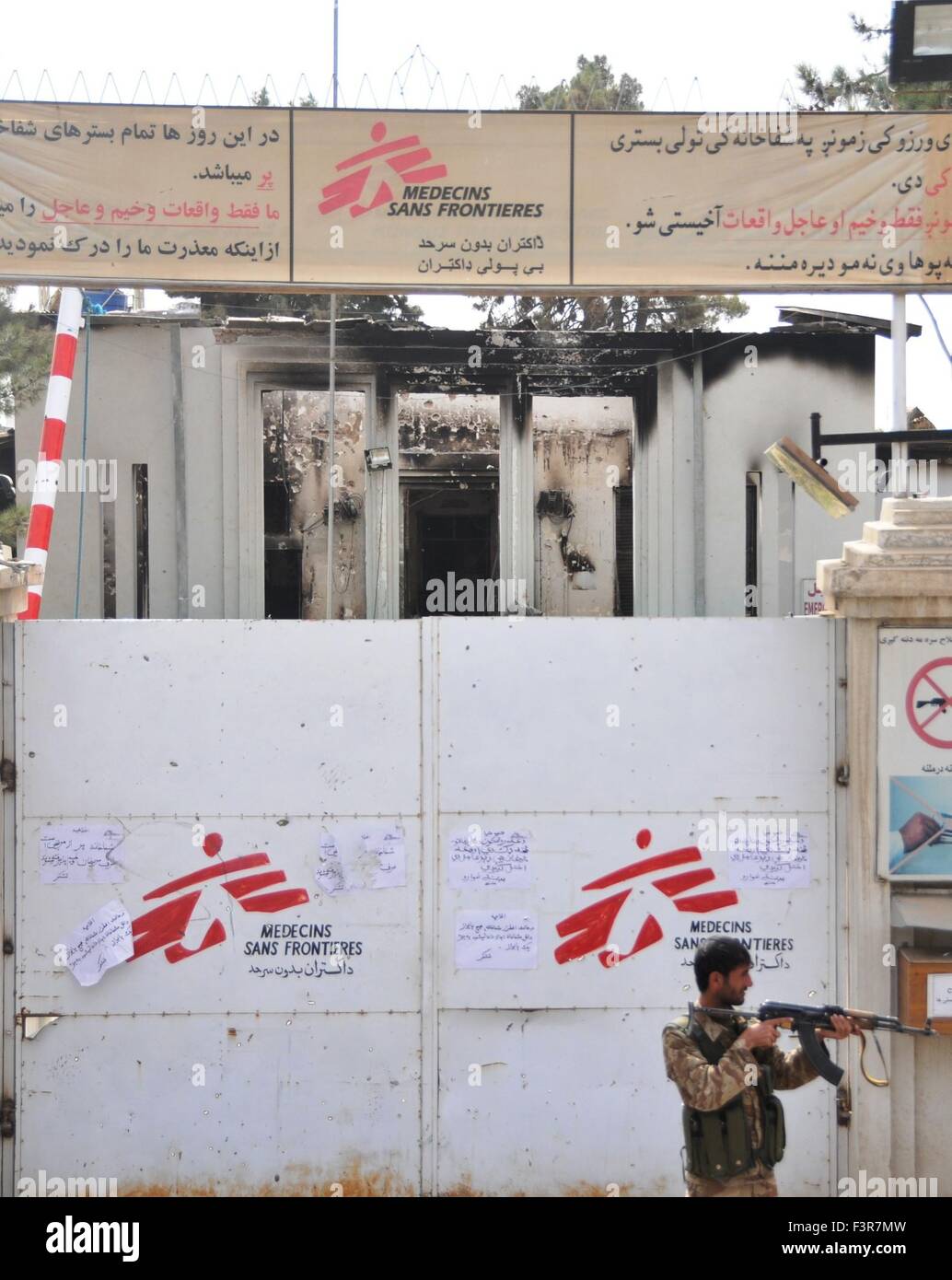 Kunduz, Kunduz provincia dell'Afghanistan. Undicesimo oct, 2015. Un poliziotto sta di guardia di fronte a Medici Senza Frontiere (MSF) ospedale distrutto da U.S. airstrike in Kunduz, la capitale del nord della provincia di Kunduz in Afghanistan, 11 ott. 2015. I bombardamenti sull'ospedale gestito dall'Medicins Sans Frontieres (medicinali senza frontiere) da forze statunitensi ha aggiunto alla miseria e alla cattiva volontà contro gli americani tra della guerra-stanco residenti afghano. Credito: Omid/Xinhua/Alamy Live News Foto Stock