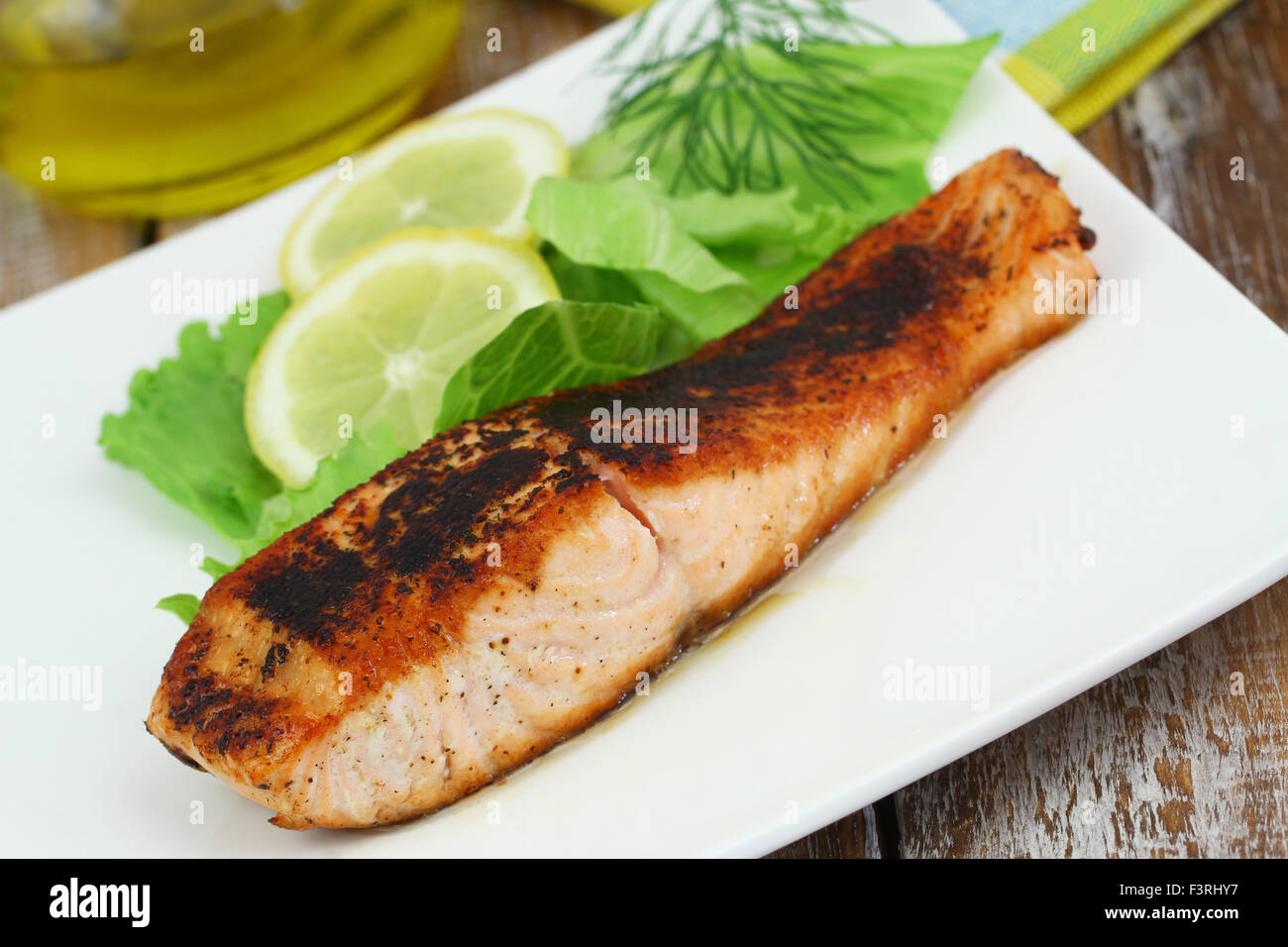 Salmone alla griglia bistecca con insalata verde e succo di limone sulla piastra bianca Foto Stock