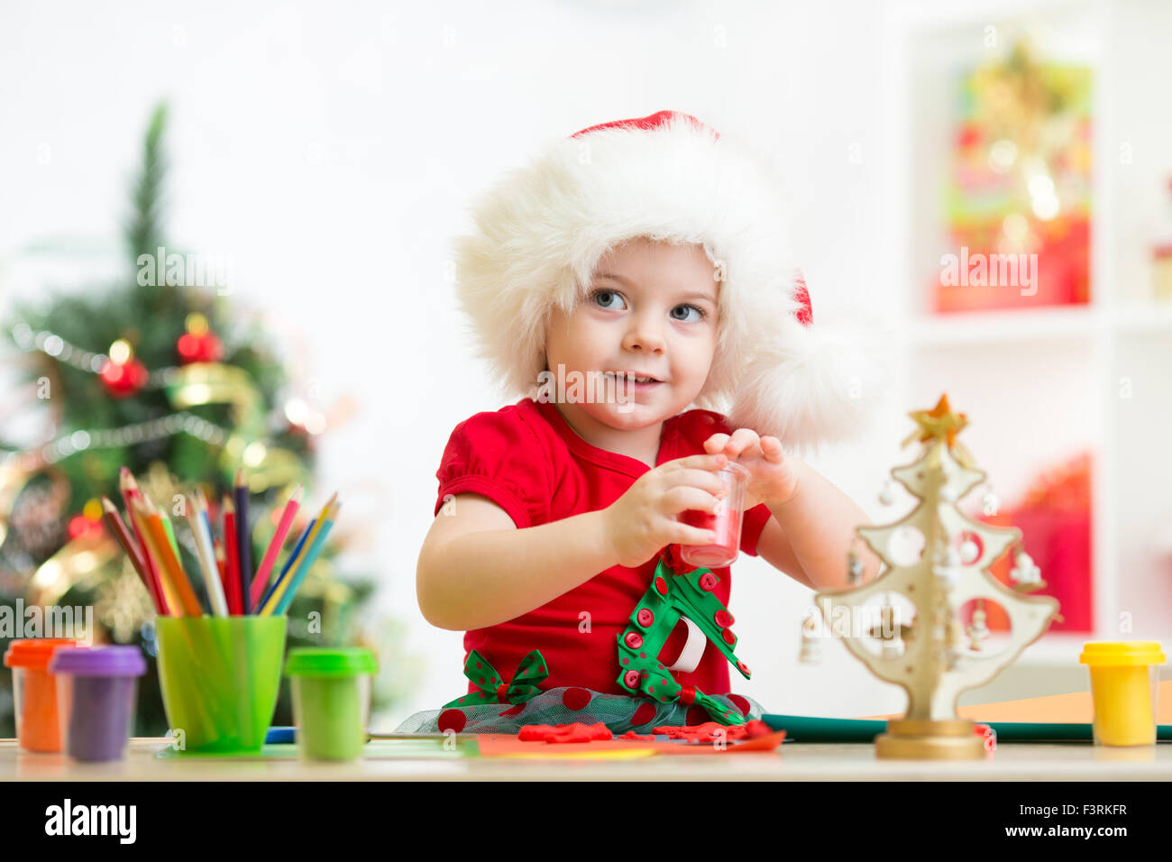 Bambino ragazza rendendo le decorazioni di Natale con gioco giocattolo di argilla Foto Stock
