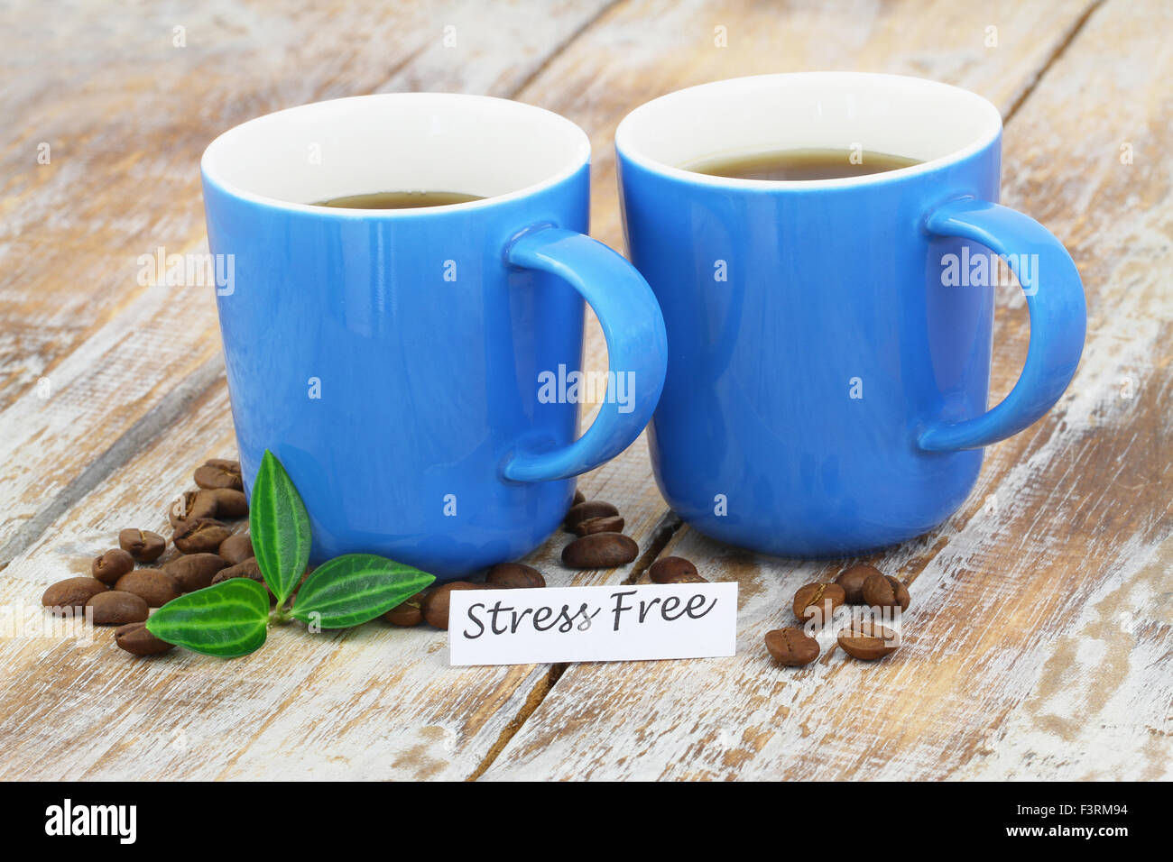Lo stress card gratuita e due tazze di caffè rustico superficie in legno Foto Stock