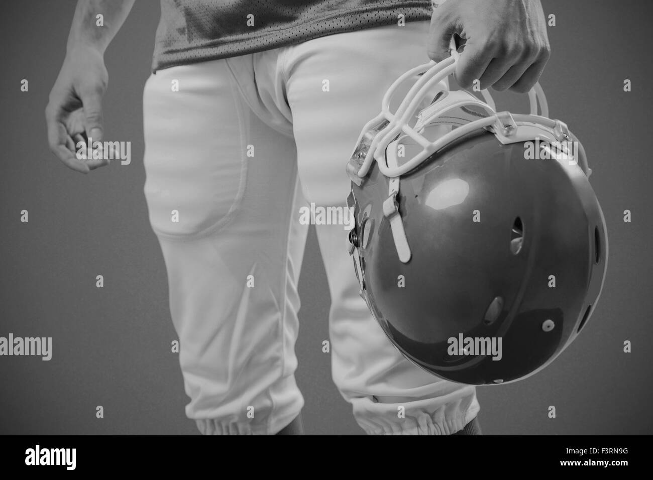 Immagine composita di un giocatore di football americano prendendo il suo casco sulla sua mano Foto Stock