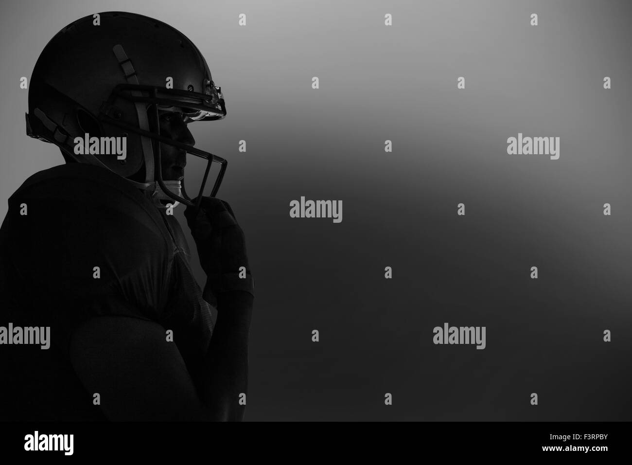 Vista laterale di silhouette giocatore di football americano che indossa il casco Foto Stock