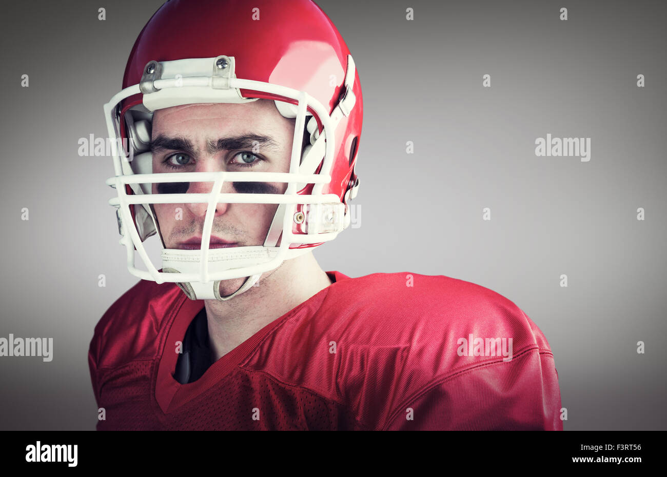 Immagine composita del ritratto di un serio giocatore di football americano prendendo il suo casco guardando camer Foto Stock