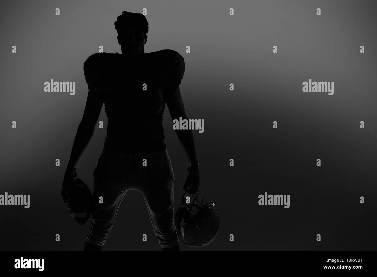 Silhouette football americano giocatore in possesso palla e casco Foto Stock