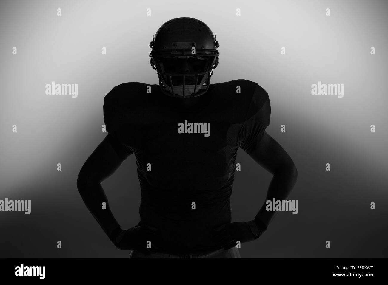 Silhouette giocatore di football americano in piedi con la mano sul hip Foto Stock
