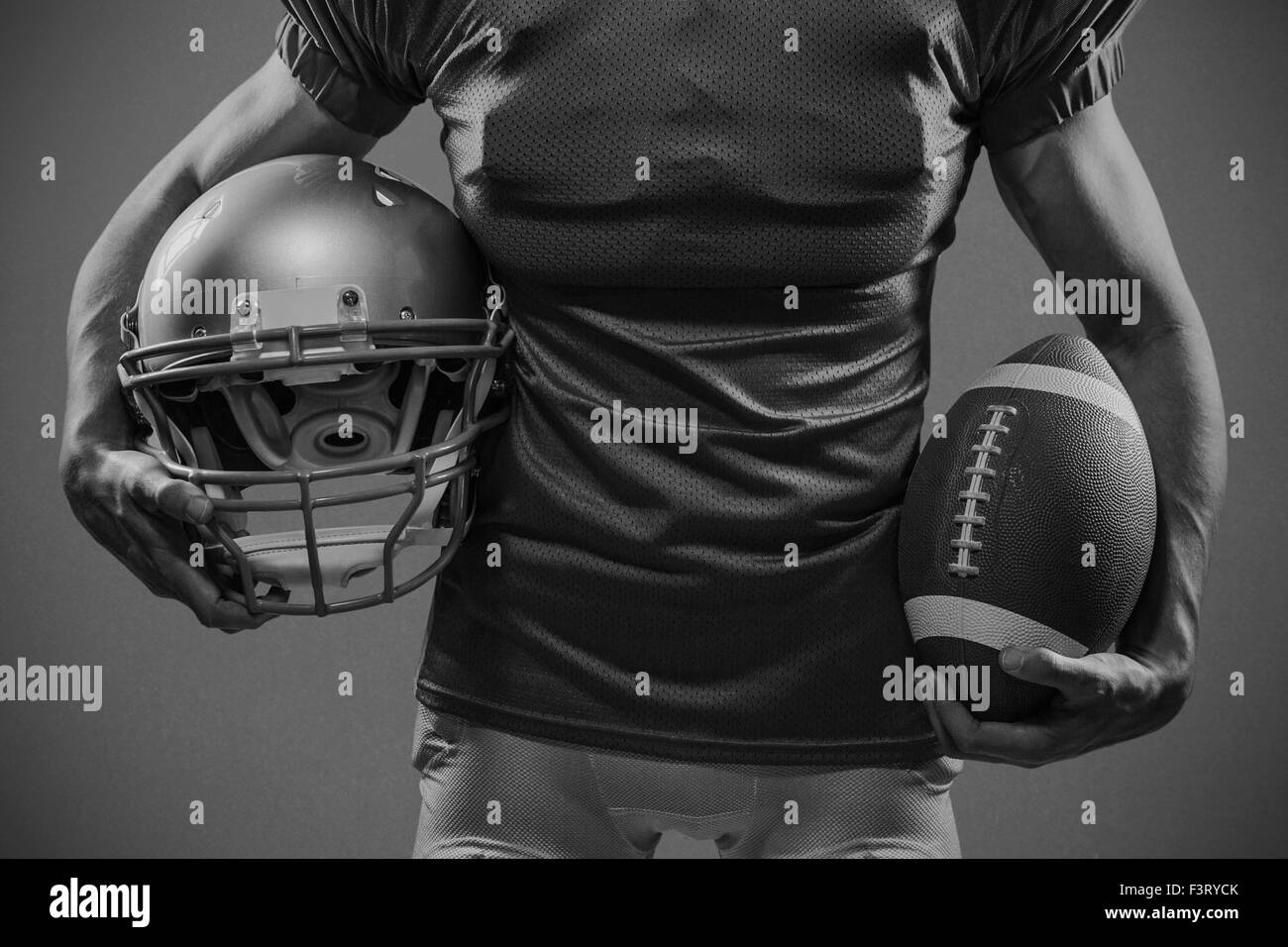 Immagine composita della sezione mediana del giocatore di football americano in maglia rossa tenendo il casco e la sfera Foto Stock