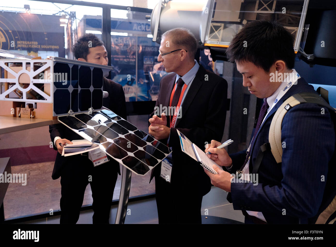 Gerusalemme, Israele. Xii Ottobre, 2015. Visitatori dal Giappone a parlare con un rappresentante dell'israeliano Rafael avanzati sistemi di difesa società presso la IAC International Astronautical Congress in Gerusalemme, Israele il 12 ottobre 2015. Israele il settore spaziale ha notevolmente sviluppato e ampliato negli ultimi anni in diverse aree di interesse. Presidente israeliano Reuven Rivlin, insieme con i rappresentanti di Google e Spacell un israeliano space engineering company, ha annunciato la scorsa settimana che Israele intende atterrare una navicella spaziale privato sulla Luna entro la fine del 2017. Credito: Eddie Gerald/Alamy Live News Foto Stock