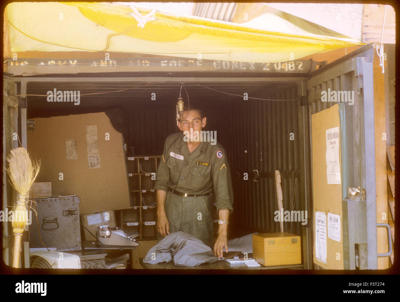 Un soldato americano dell'esercito degli Stati Uniti sta all'interno di un contenitore di conex al Cam Rahn Bay, una posizione del 1° Comando Logistico, durante la Guerra del Vietnam. Foto Stock