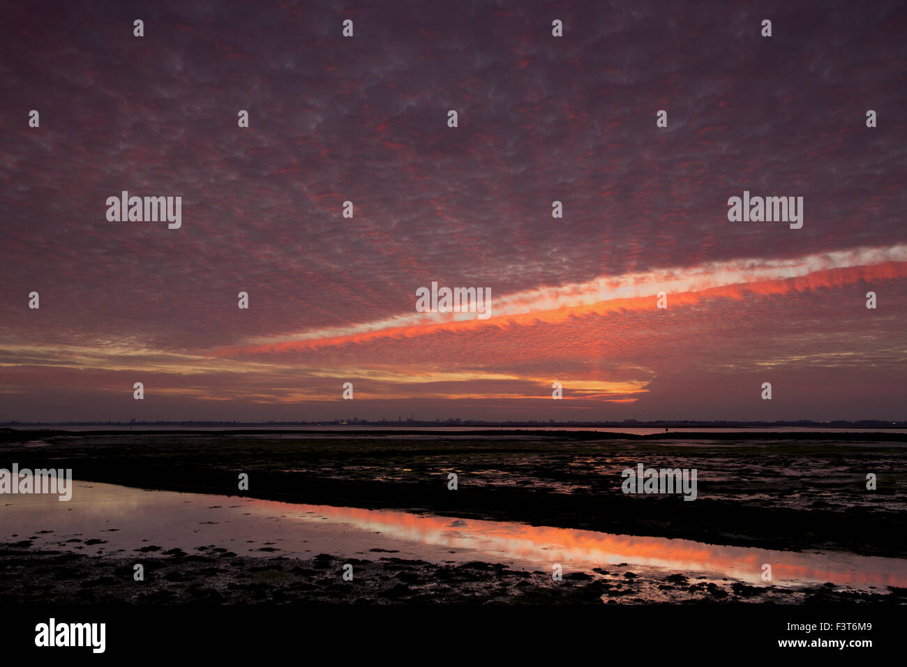 Tramonto spettacolare con insolite formazioni di nubi. Alien sky con un rip tra le nuvole. Langstone harbour vicino a Havant Portsmouth Foto Stock