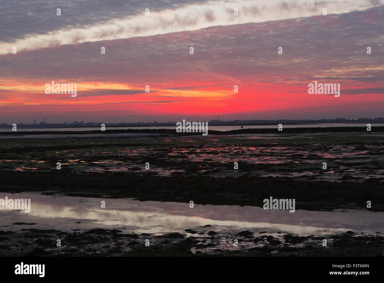 Tramonto spettacolare con insolite formazioni di nubi. Alien sky con un rip nella cloud. Langstone harbour vicino a Portsmouth Foto Stock